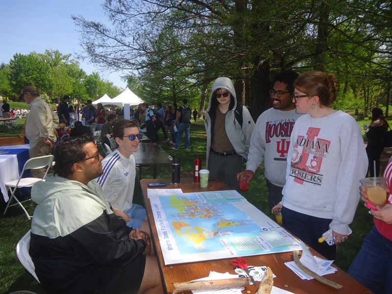 Students gathered around the FinTech booth table outdoors