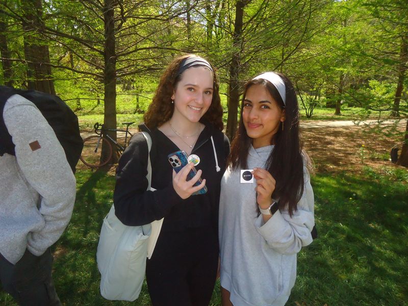 Two members holding FinTech stickers outdoors