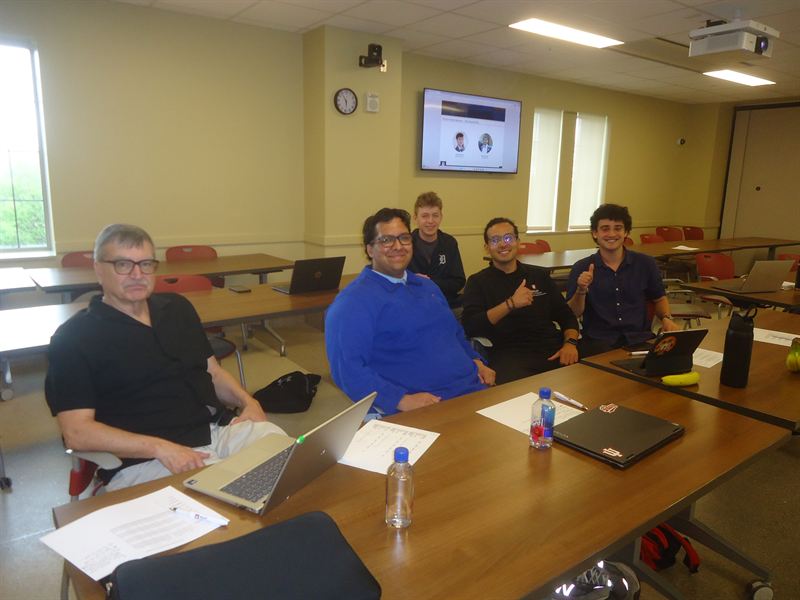 Judges and members seated around a table in a Kelley classroom